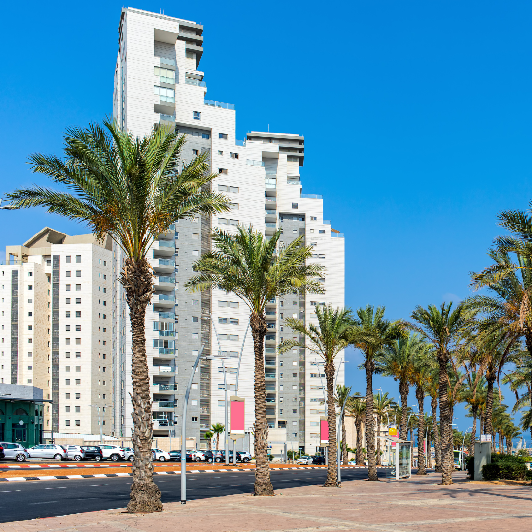 תמונה המתארת קבוצת תושבים מבוגרים בלבוש מסורתי על רקע פרויקטי בנייה חדשים.